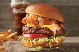 Hearty THE BLOOMIN' BURGER served on a toasted bun with fresh toppings and signature sauce